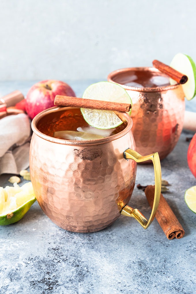 apple cider moscow mules in copper mugs on grey board