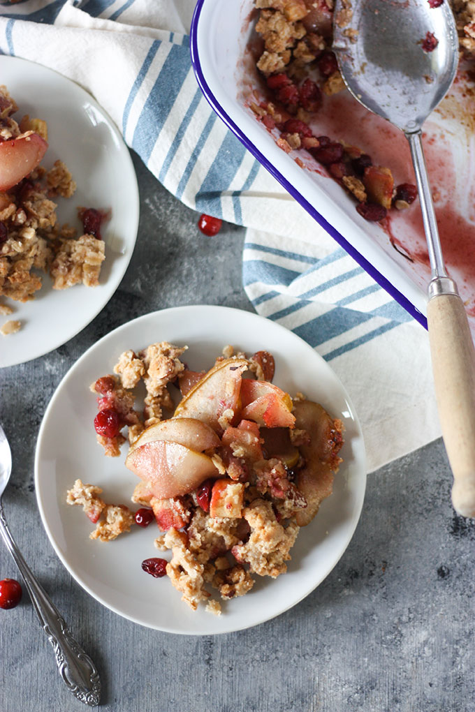 close up white plate filled with apple and pear crisp