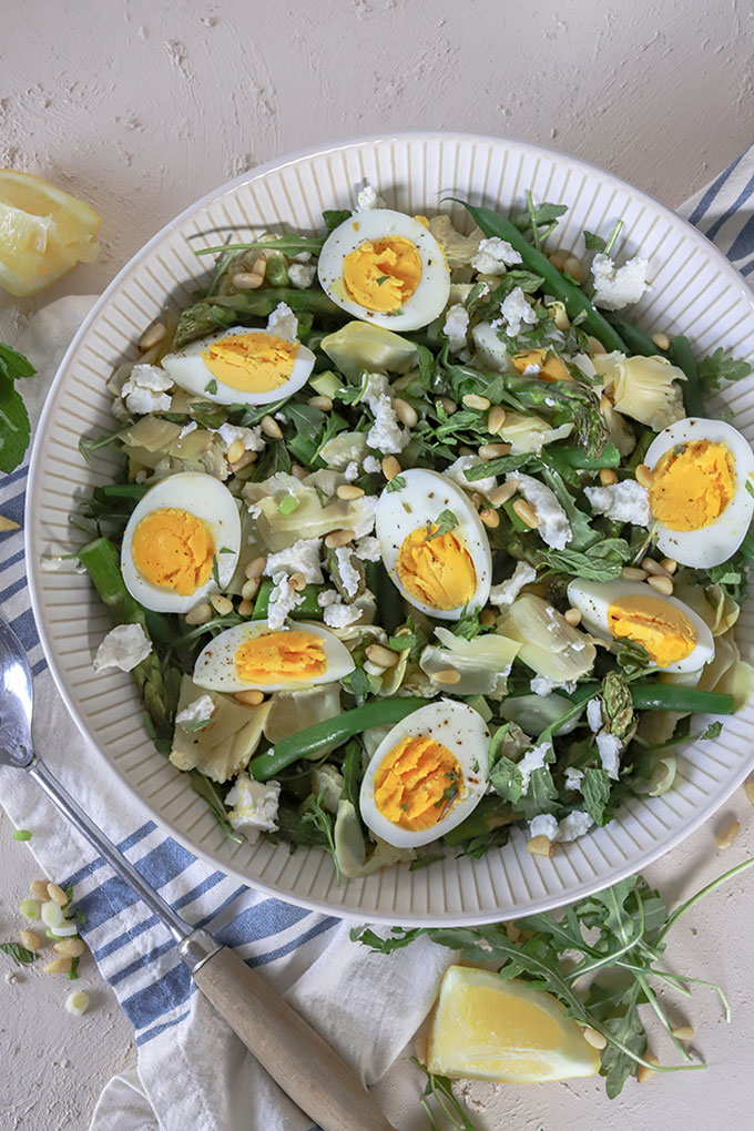 overhead view of artichoke salad with rustic spoon on left hand side of bowl