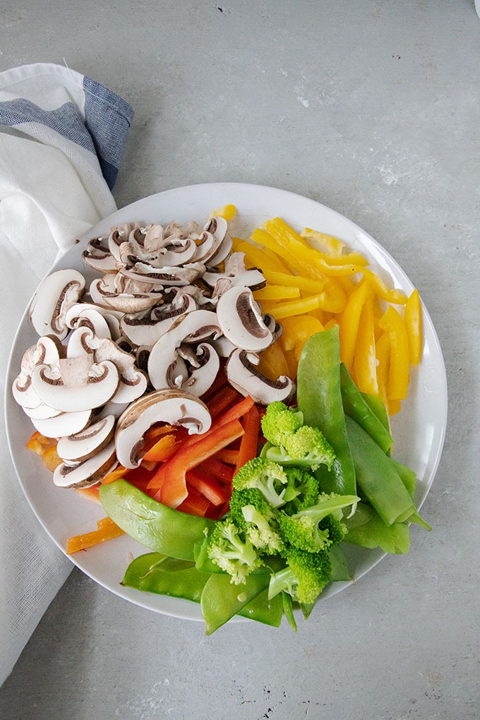 asian noodle salad vegetables on plate - peppers, snow peas, broccoli and mushrooms