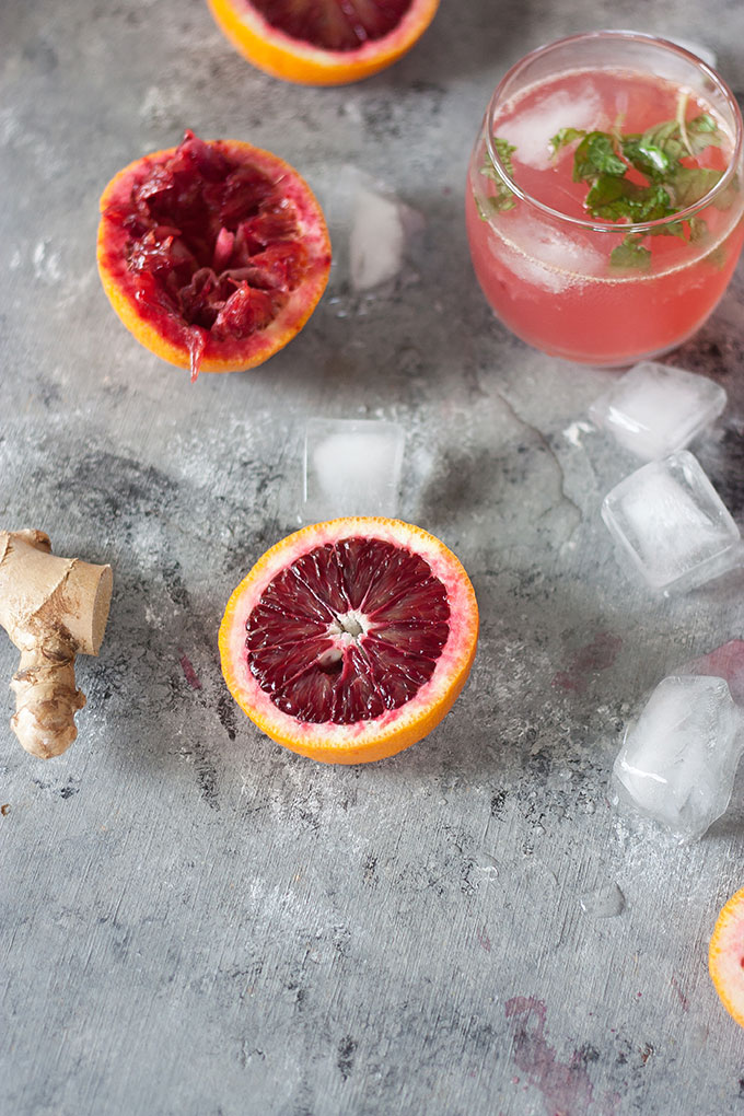 half a blood orange on a grey backdrop