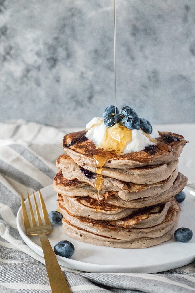 stack of kefir pancakes with maple syrup being poured over from top