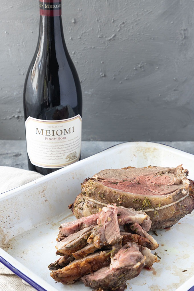 cooked boneless lamb roast with Pinot Noir bottle