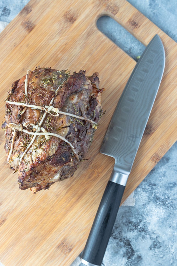 cooked boneless lamb roast on wooden board