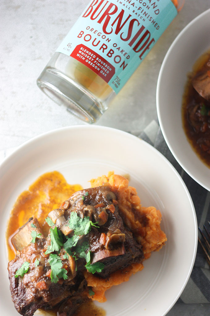 bottle of burnside bourbon featured top of a plate of bourbon ribs on mash