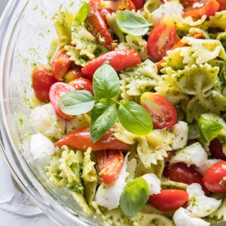 caprese salad in clear bowl on red and white linen