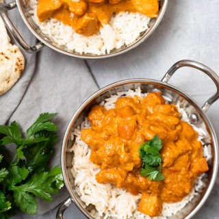 two dishes of chicken massaman curry on grey board