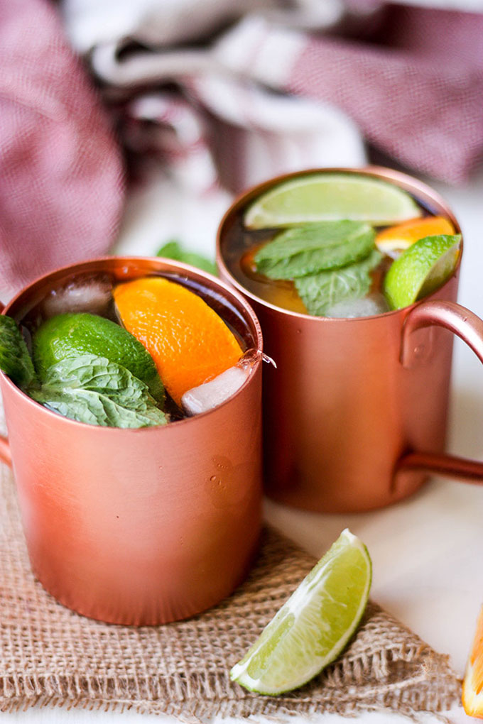 two spiced citrus cocktails in moscow mule mugs