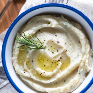 creamy cauliflower mash in white bowl with blue rim