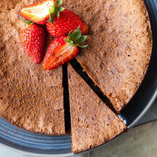 flourless chocolate torte on blue plate with one piece cut