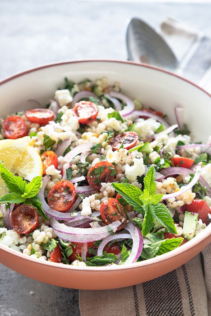 israeli couscous salad in white terracotta bowl