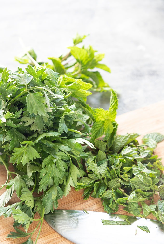 fresh mint and parsley on wooden cutting board