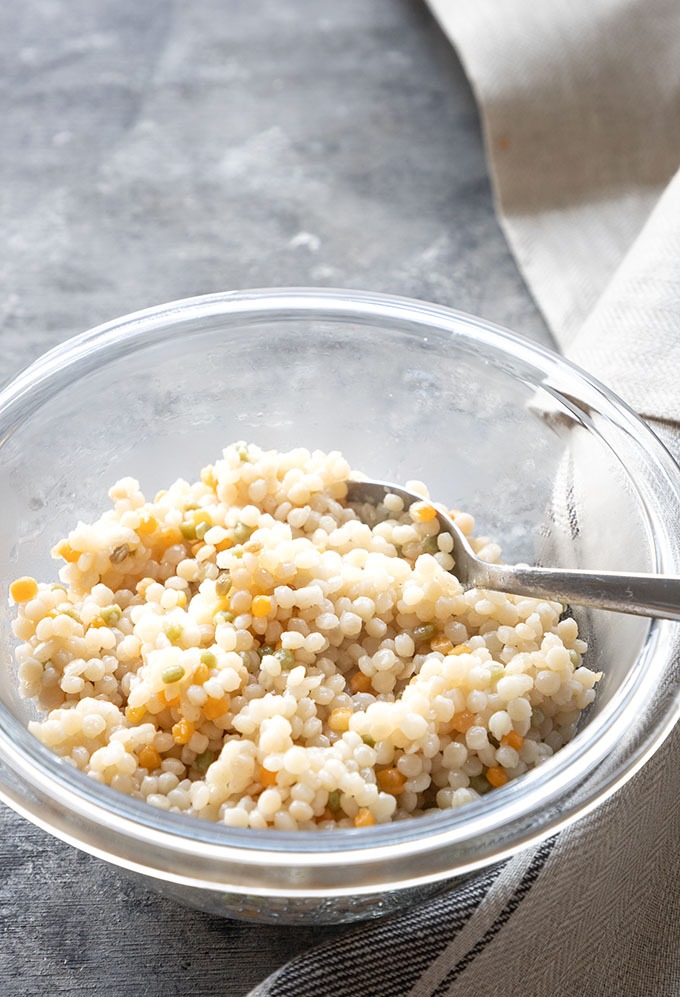 cooked israeli couscous in clear bowl