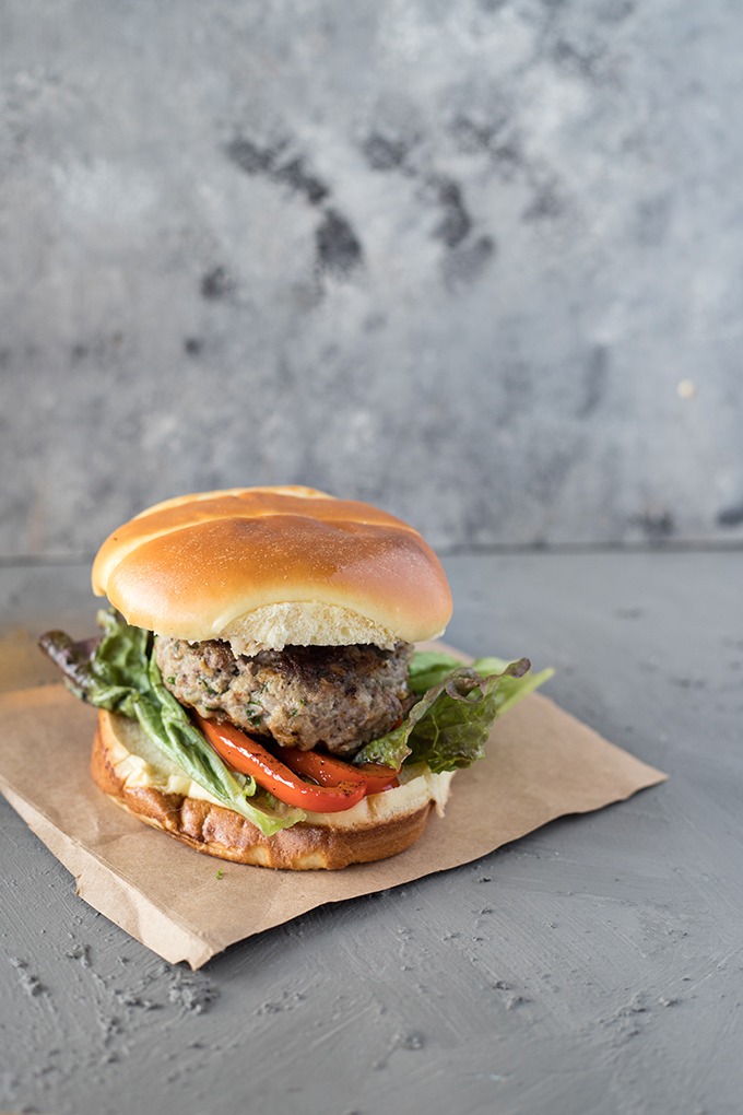 single lamb burger with feta on brown parchment paper 