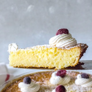 slice of lemon coconut tart being held up in front of rest of pie