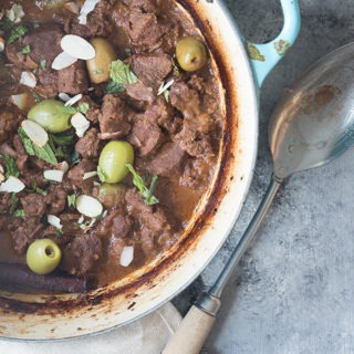 dutch oven full of moroccan lamb tagine on grey board