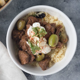 close up white bowl of moroccan lamb tagine with couscous