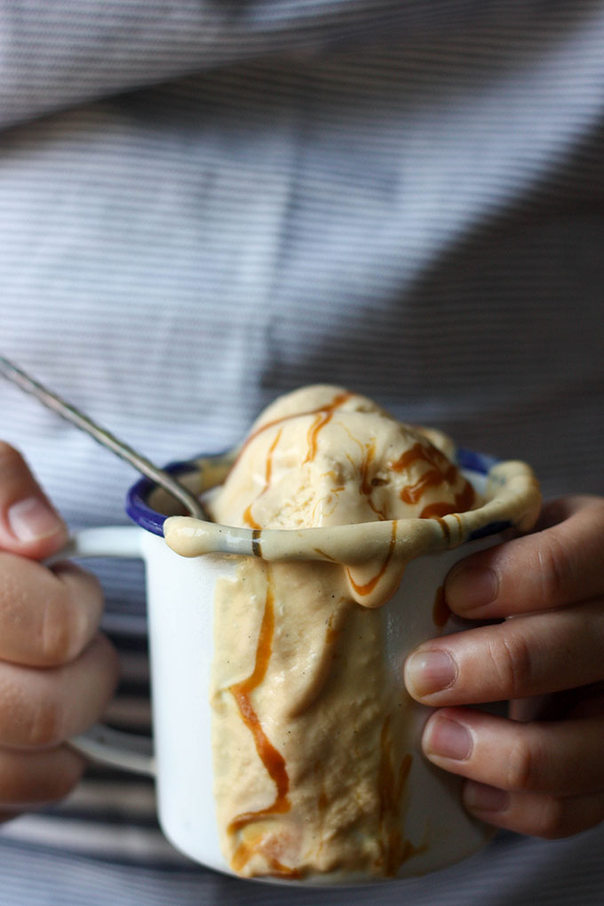 two hands holding no churn ice cream in an enamel mug