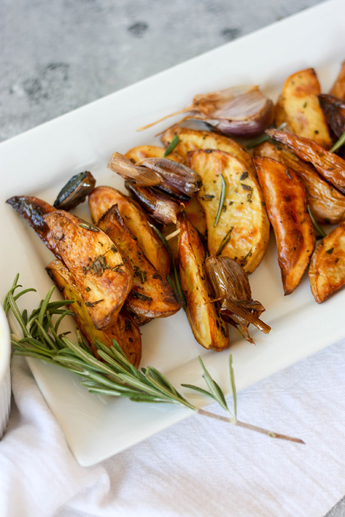 oven baked fries on white plate with rosemary sprig