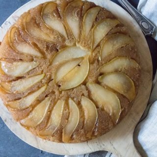 pear upside-down cake on a round wooden board