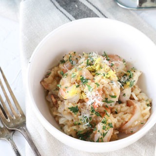 prawn risotto in white bowl with two antique forks