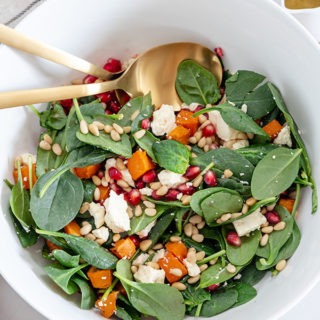 roasted sweet potato salad in white bowl on wooden board