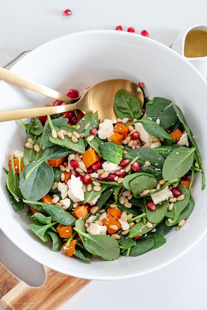 roasted sweet potato salad in white bowl on wooden board