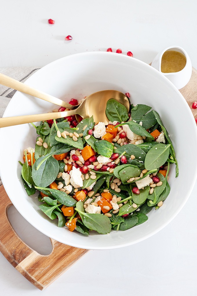 roasted sweet potato salad in white bowl on wooden board