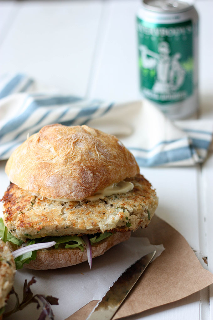 salmon burger topped with a ciabatta roll on a brown piece of paper