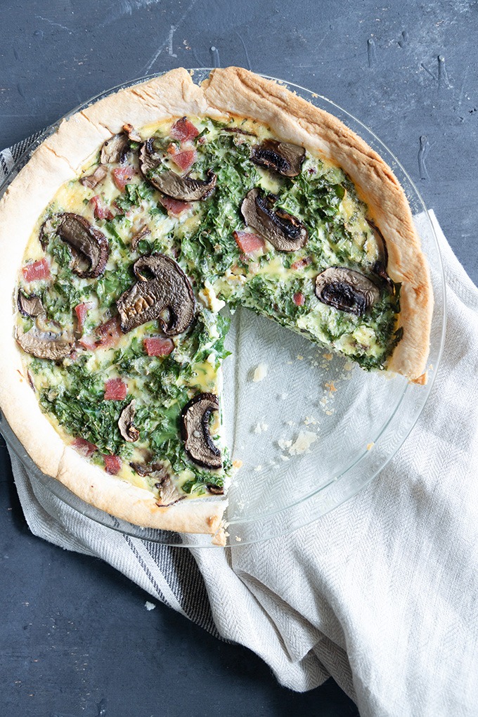 piece of quiche missing from whole quiche in glass pie dish