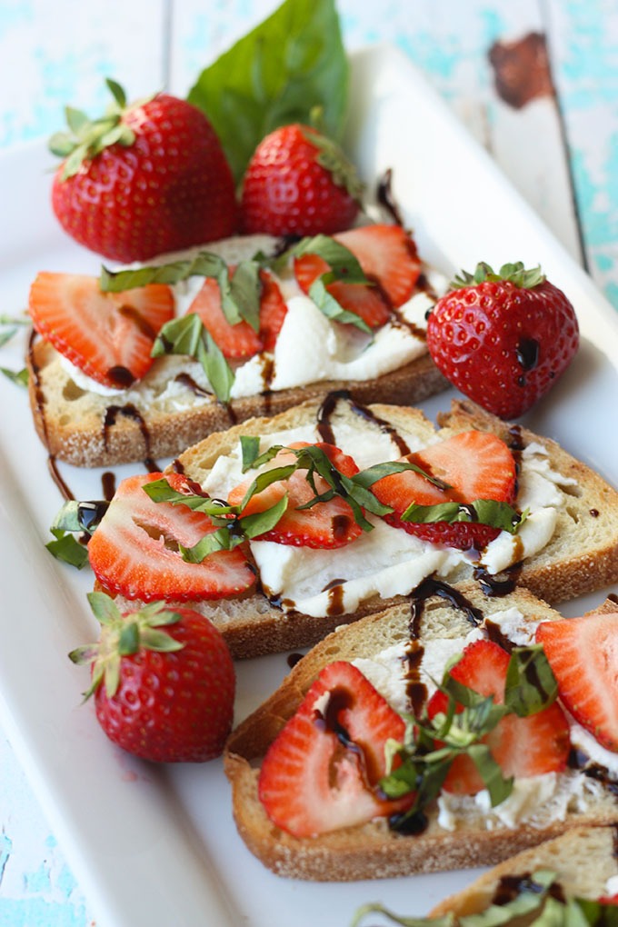 close up of strawberry bruschetta on a white plate