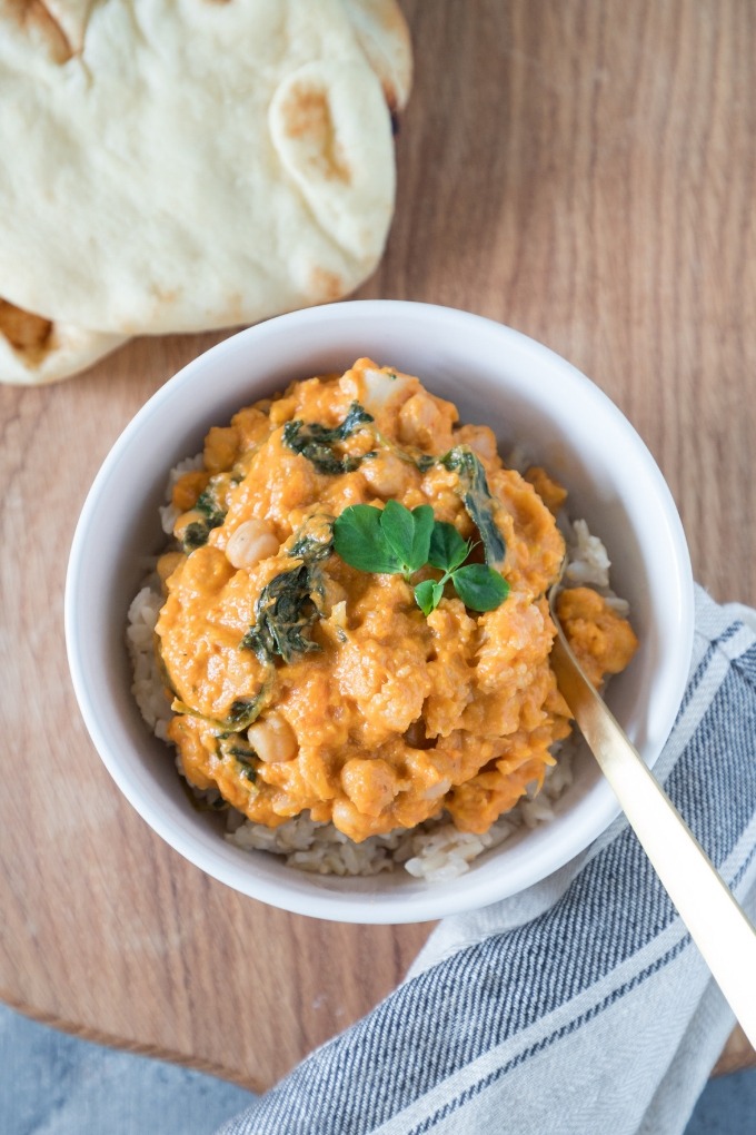 sweet potato chickpea curry in white bowl with gold fork