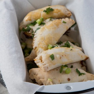 shrimp empanadas in a black and white enamel loaf pan, on a grey napkin