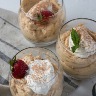 three glasses of dulce de leche mousse on grey napkin