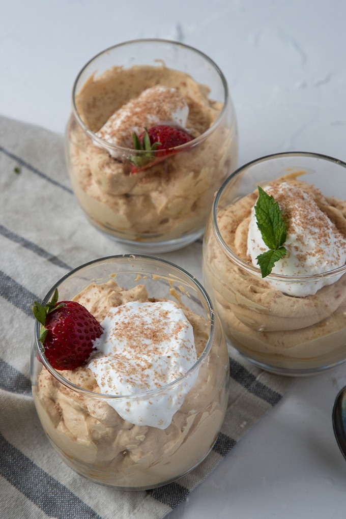 three glasses of dulce de leche mousse on grey napkin