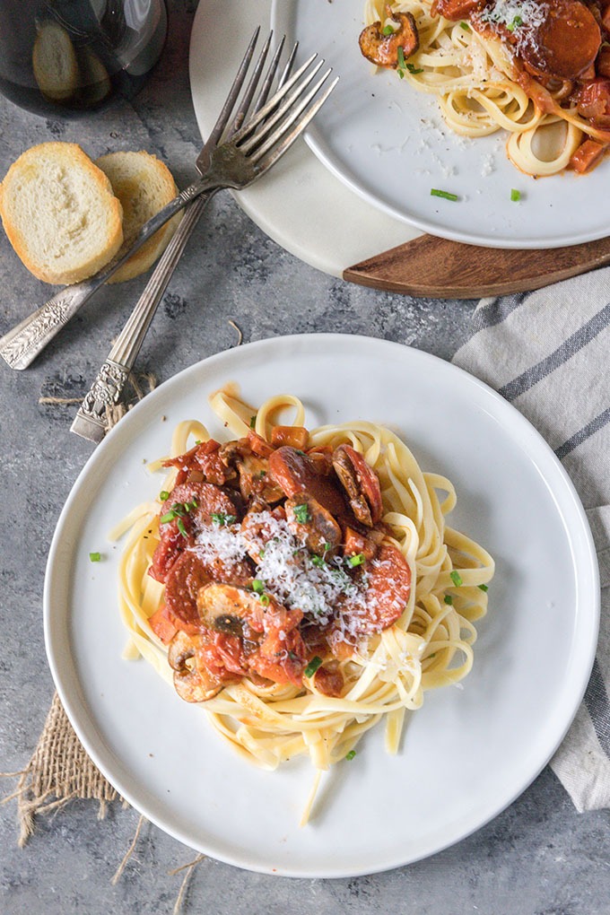 tomato chorizo pasta on white plate