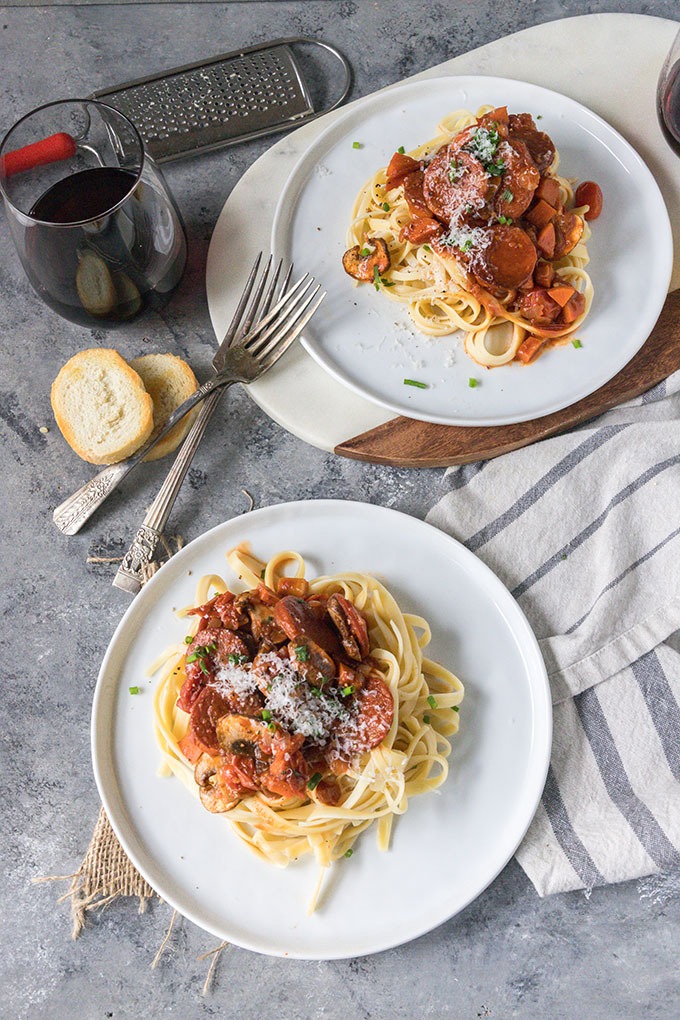 two plates of tomato chorizo pasta