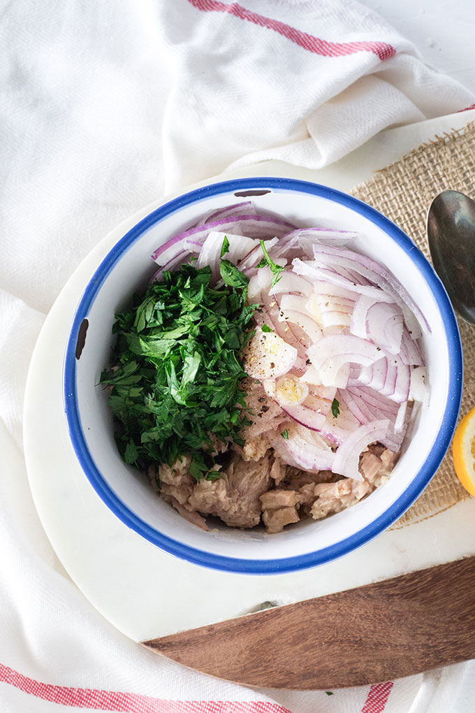 step one - tuna, lemon, olive oil, parsley and onion in bowl